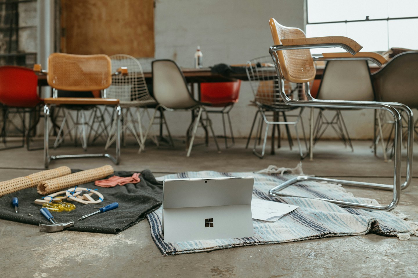 Attrezzi e materiali per il restauro di mobili disposti vicino a un laptop.